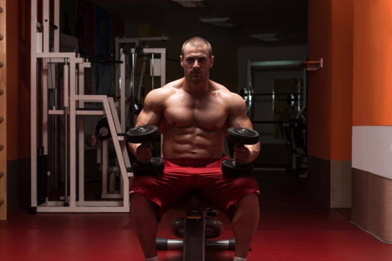 young-bodybuilder-working-out-biceps-dumbbell-concentration-curls-min